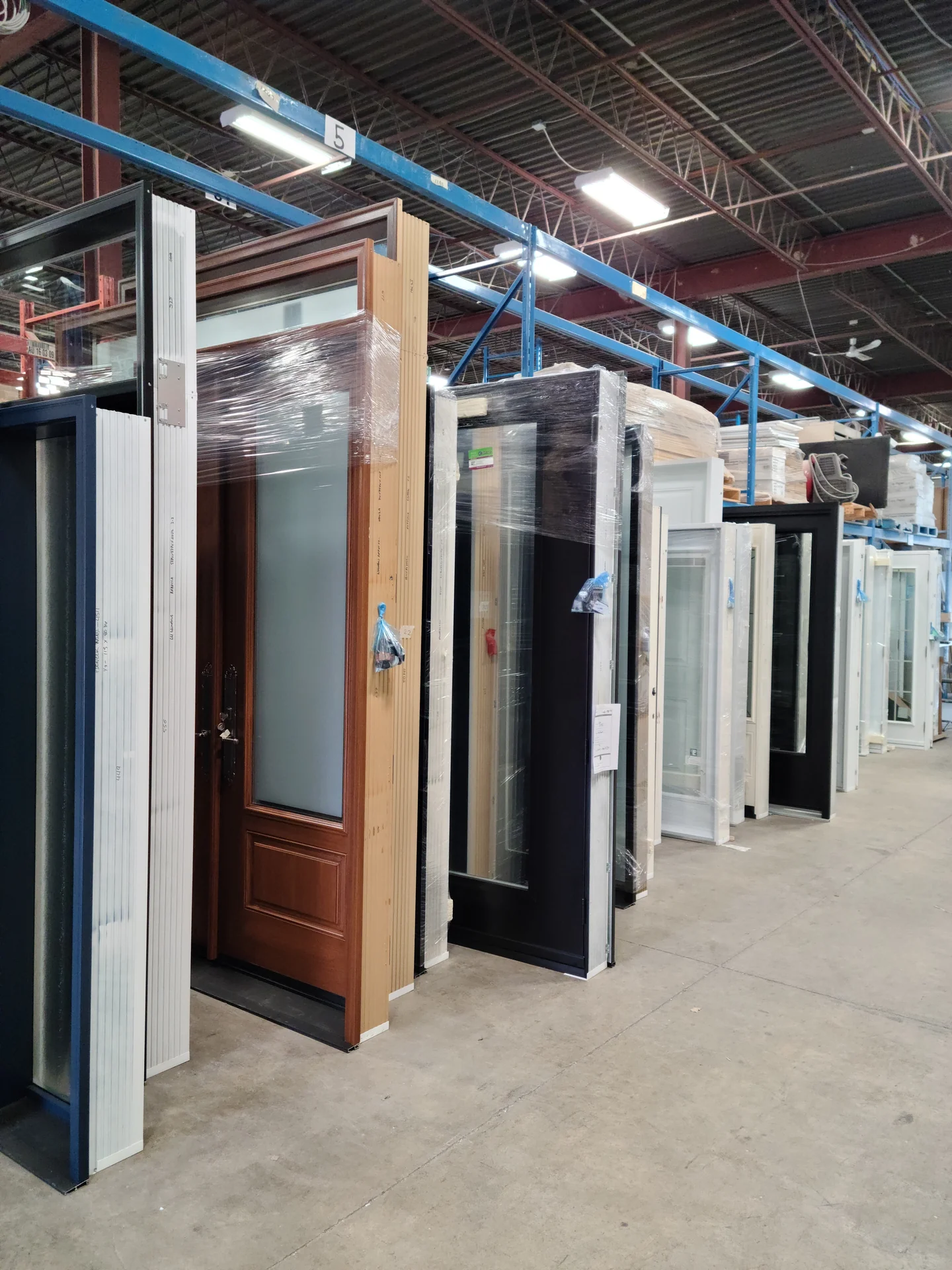 Custom entry doors with different finishes and glass designs at the Palma manufacturing facility