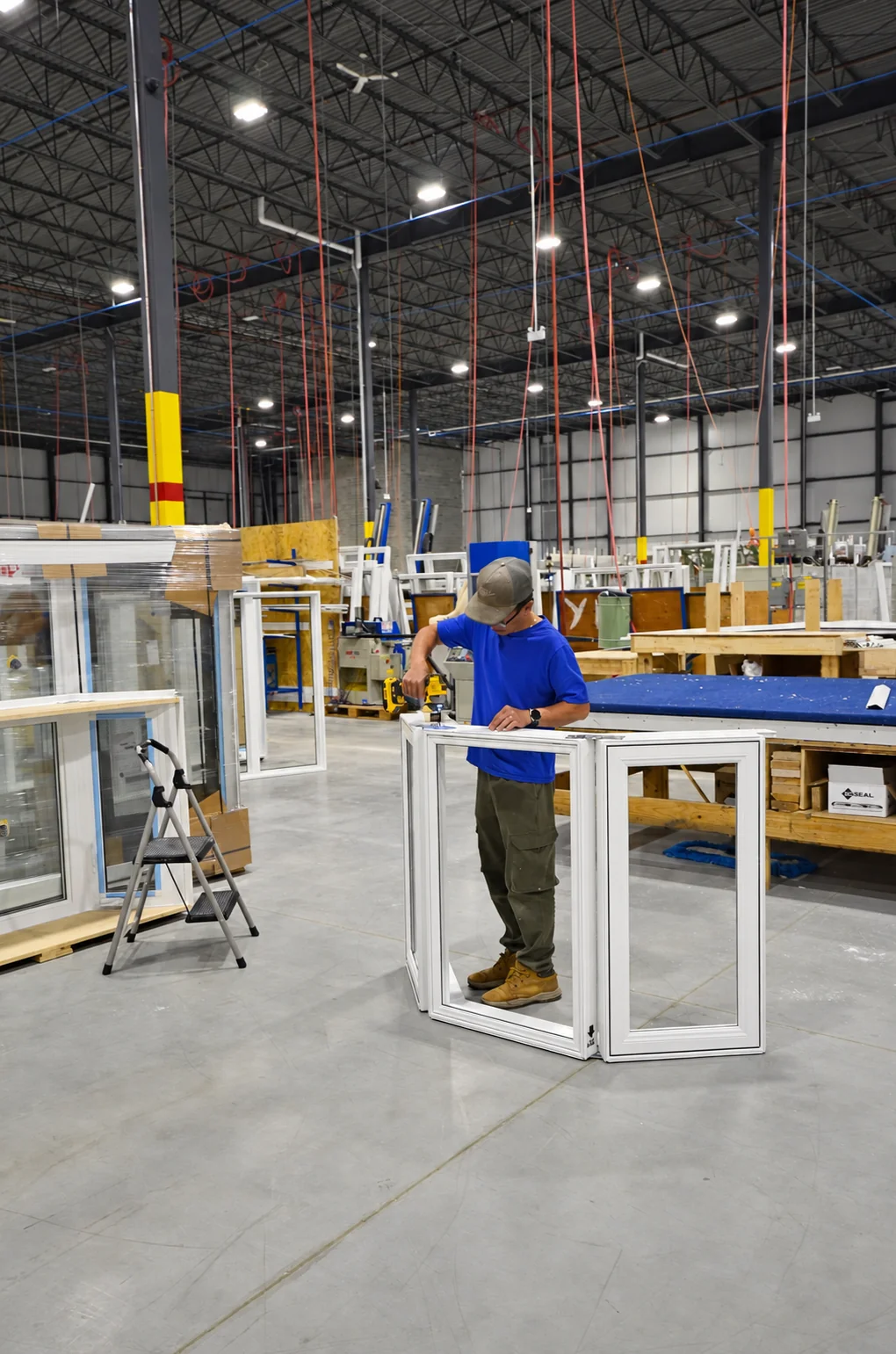 A worker assembling hardware on a vinyl window frame